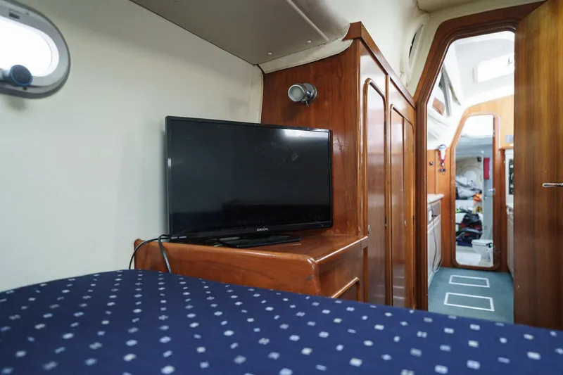 Solitude Yacht Photos Pics Interior of 1995 Prout 45 yacht with TV, wooden cabinetry, and polka dot bedding.