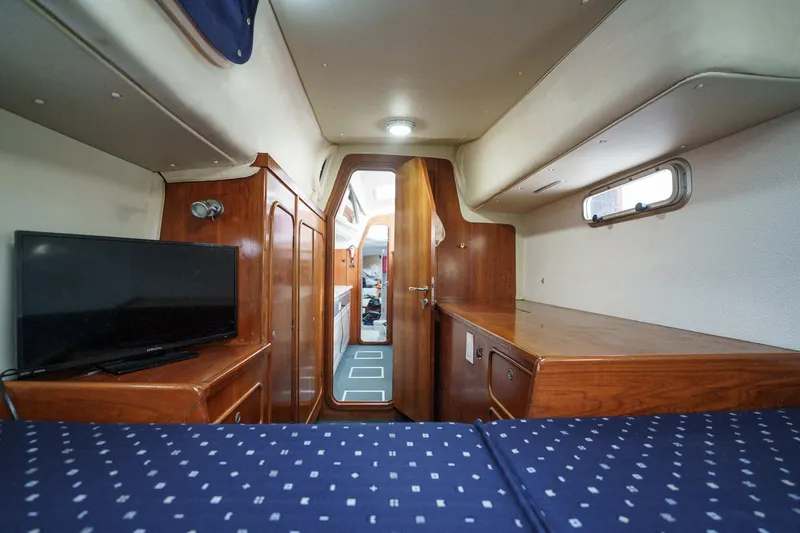Solitude Yacht Photos Pics Interior of 1995 Prout 45 yacht cabin with wood furnishings and a small TV.
