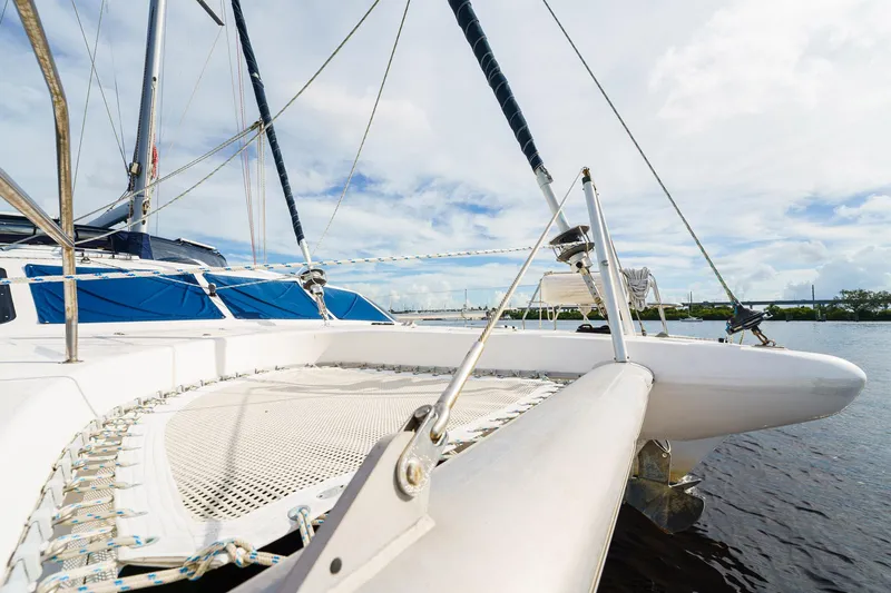 Solitude Yacht Photos Pics 1995 Prout 45 catamaran on water, featuring deck and netting under a cloudy sky.