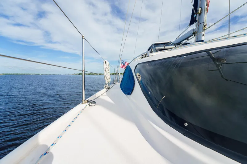 Solitude Yacht Photos Pics Sailing on a 1995 Prout 45 catamaran, ocean view, clear sky, American flag.