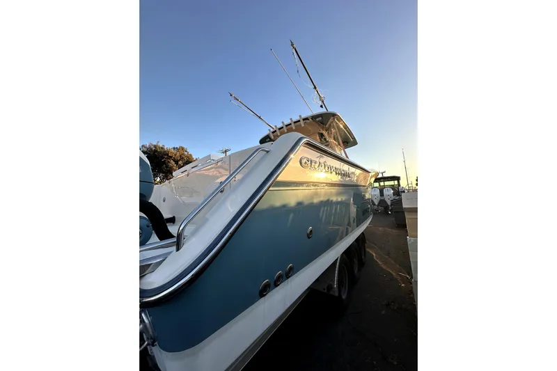 Killer B Yacht Photos Pics 2019 Grady-White Canyon 336 boat, docked at sunset, showcasing sleek design and fishing rods.