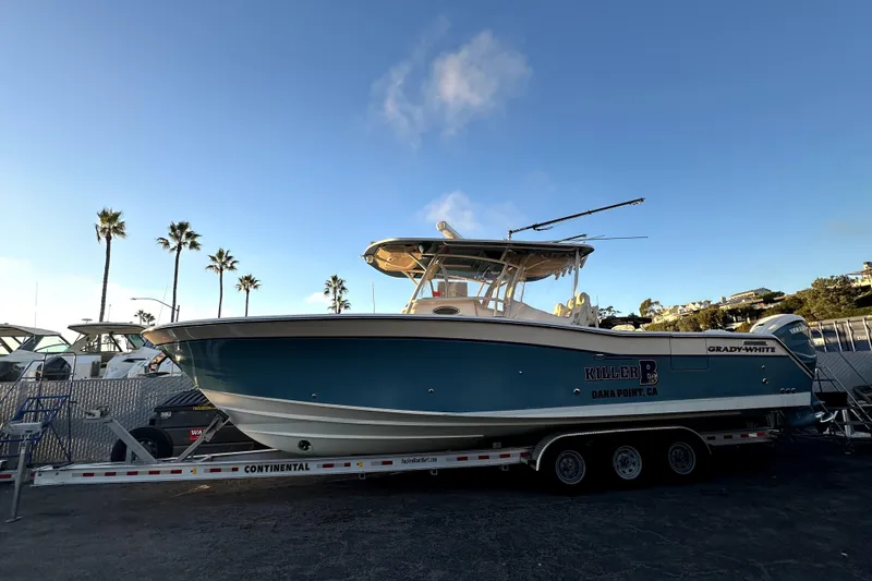 Killer B Yacht Photos Pics 2019 Grady-White Canyon 336 boat on trailer, palm trees in background, clear sky.