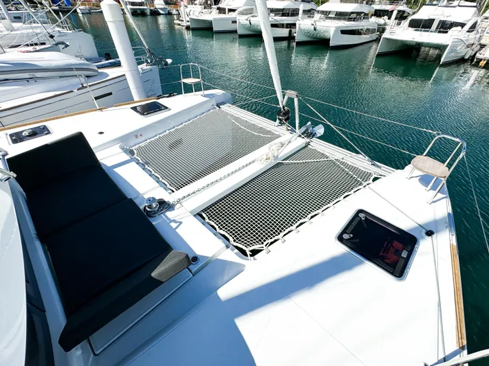 Cloud Walker Yacht Photos Pics 2024 Lagoon 40 catamaran with netted deck, docked in a marina.
