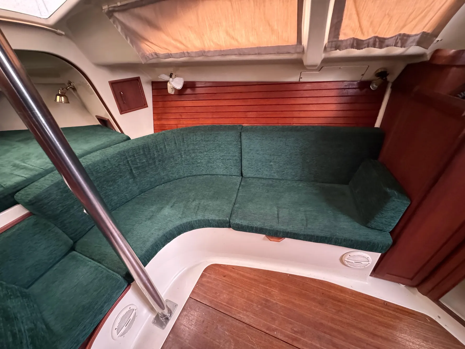 Interior of a 1994 Hunter 29.5 sailboat with green seating and wood accents.