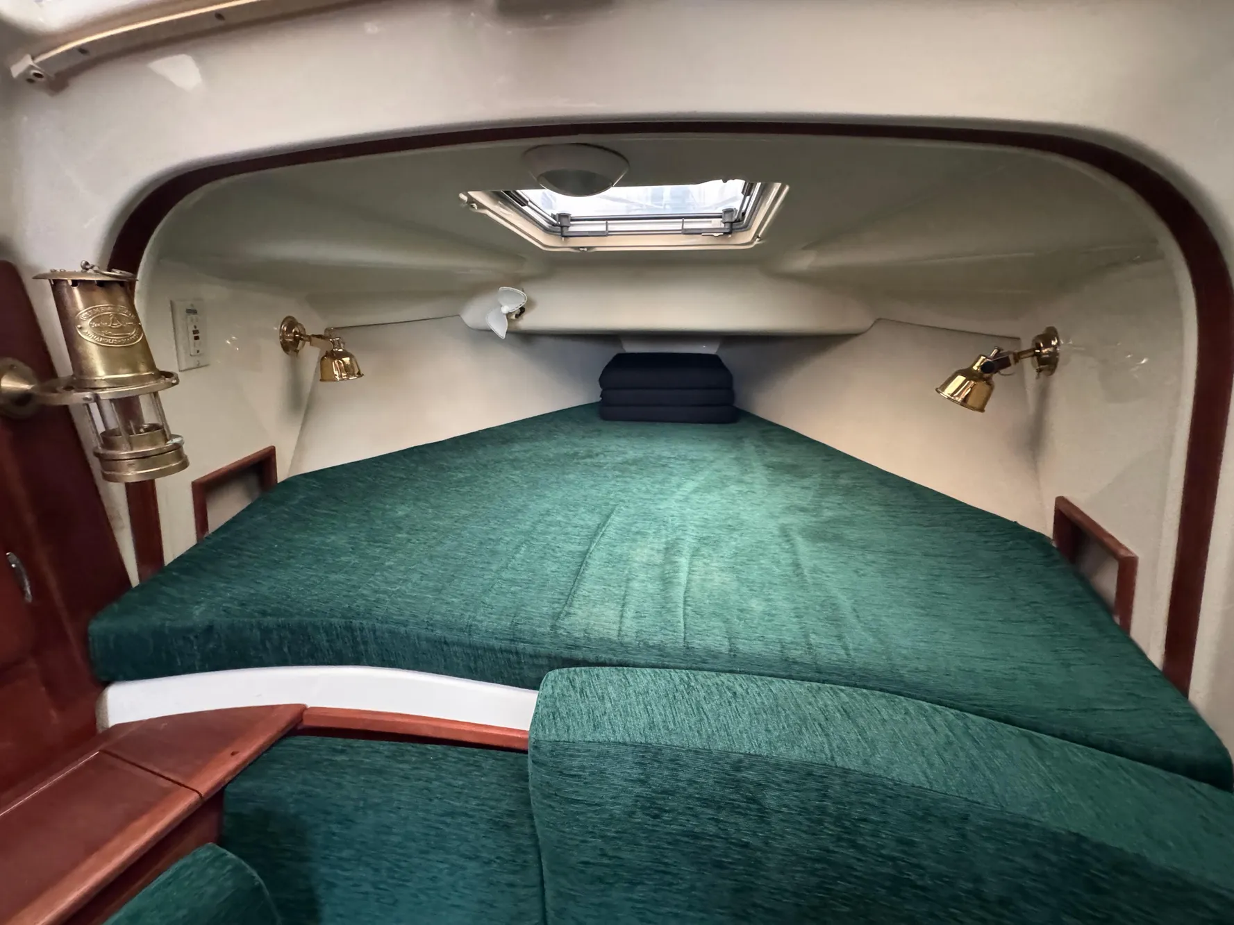 1994 Hunter 29.5 sailboat cabin with green bedding and brass lamps.
