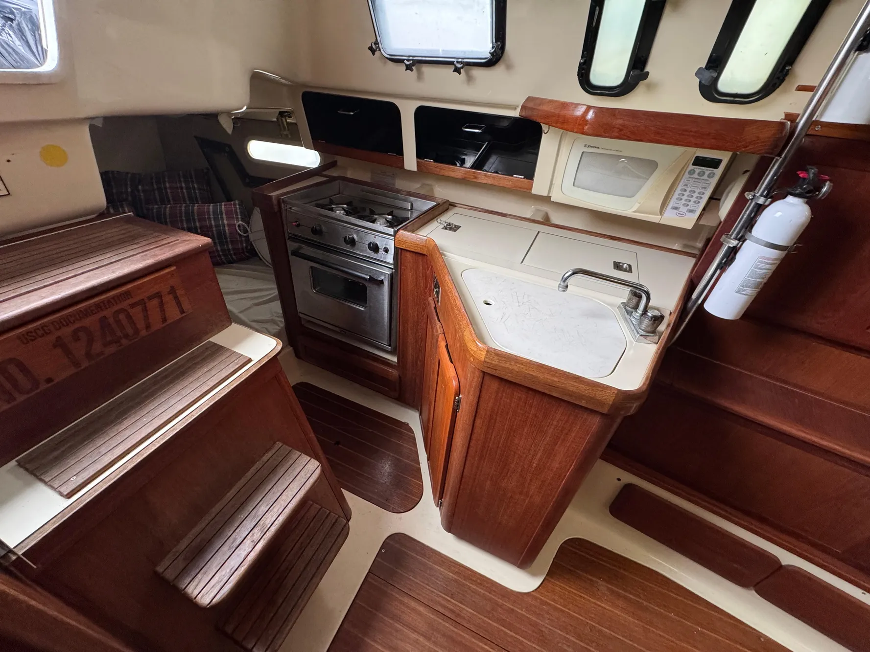 Interior of a 1994 Hunter 29.5 sailboat with kitchen and wooden cabinetry.