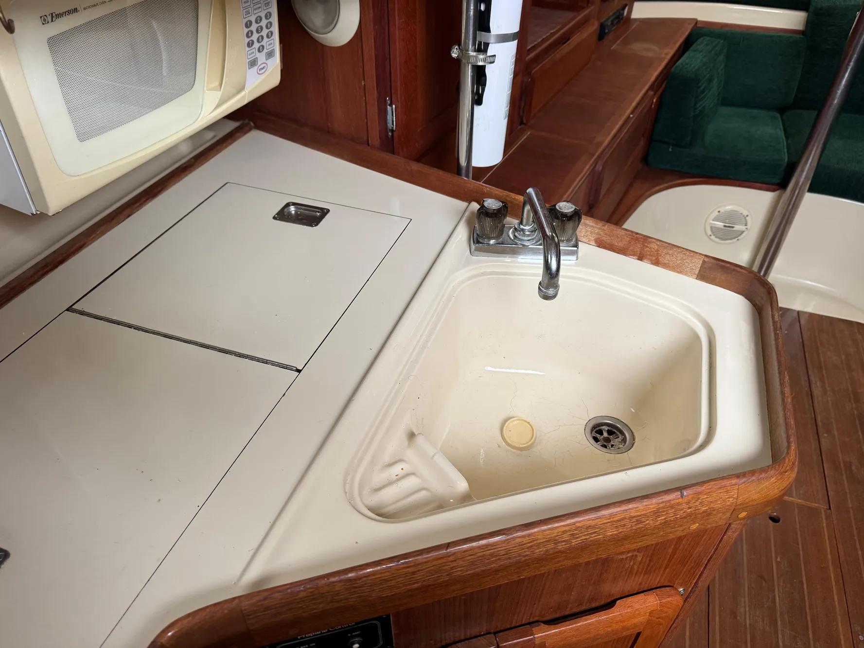 1994 Hunter 29.5 yacht kitchen with sink, microwave, and wooden cabinetry.