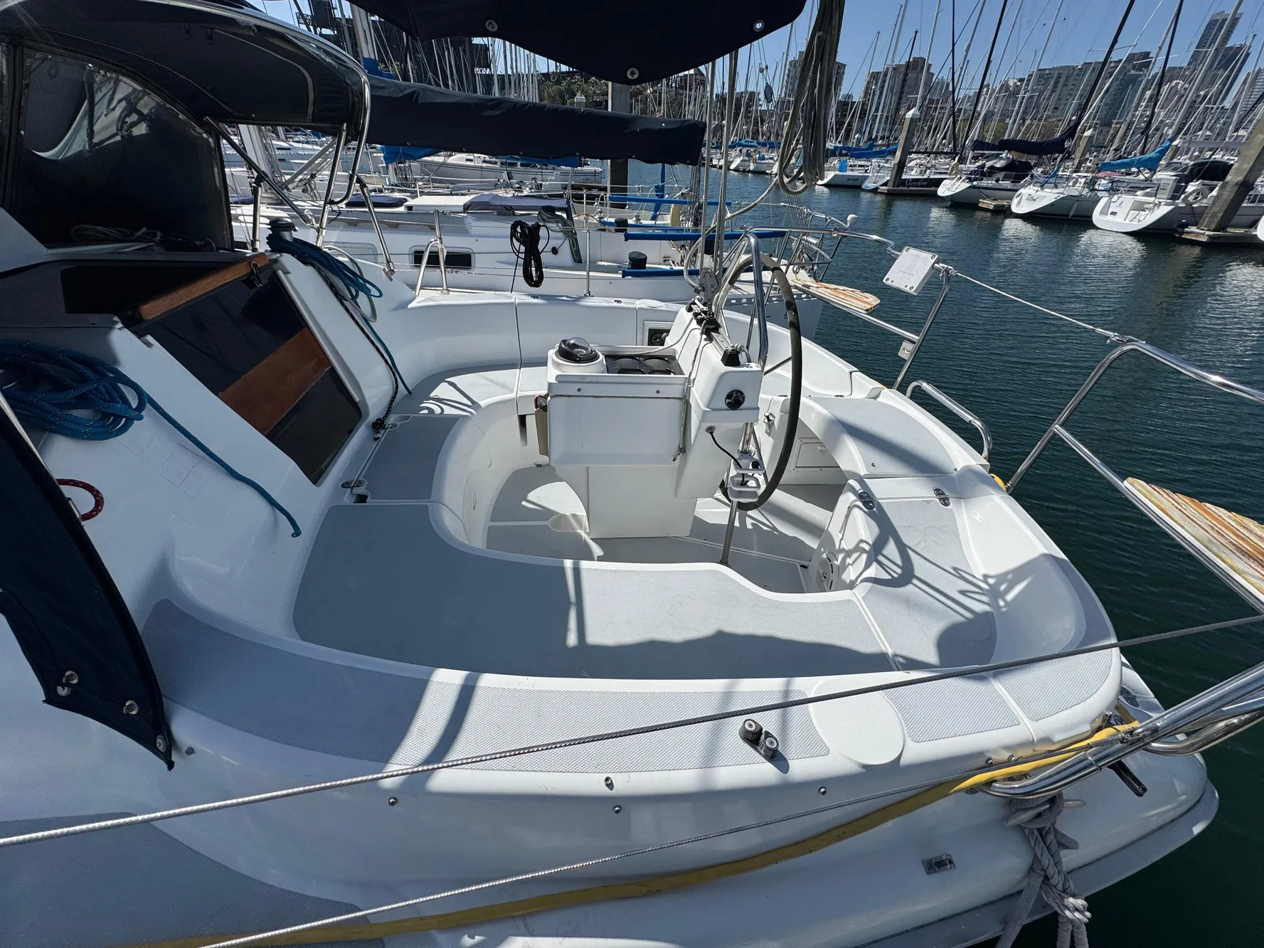 1994 Hunter 29.5 sailboat cockpit with steering wheel, docked in marina.