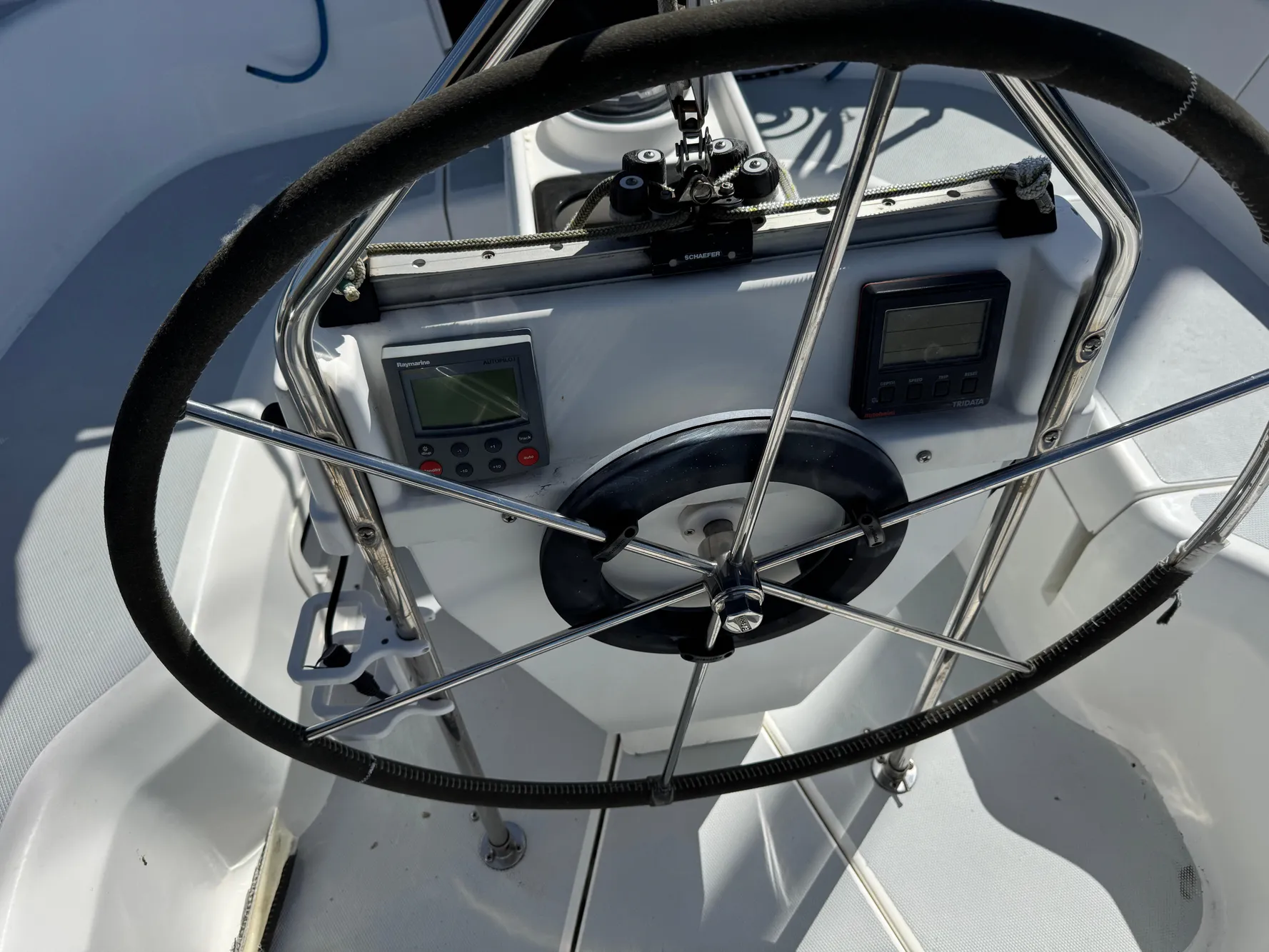 Steering wheel and controls of a 1994 Hunter 29.5 sailboat cockpit.