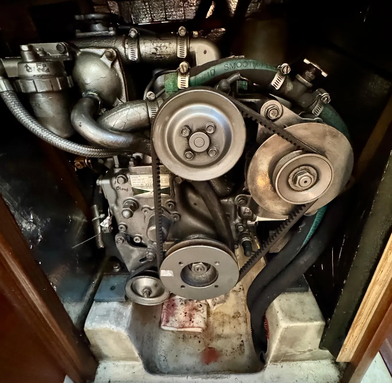 Engine of a 1994 Hunter 29.5 sailboat, showcasing belts and pulleys.