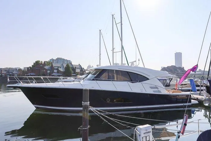 Eagle Yacht Photos Pics 2016 Riviera 525 SUV yacht docked in a marina, reflecting on calm water.