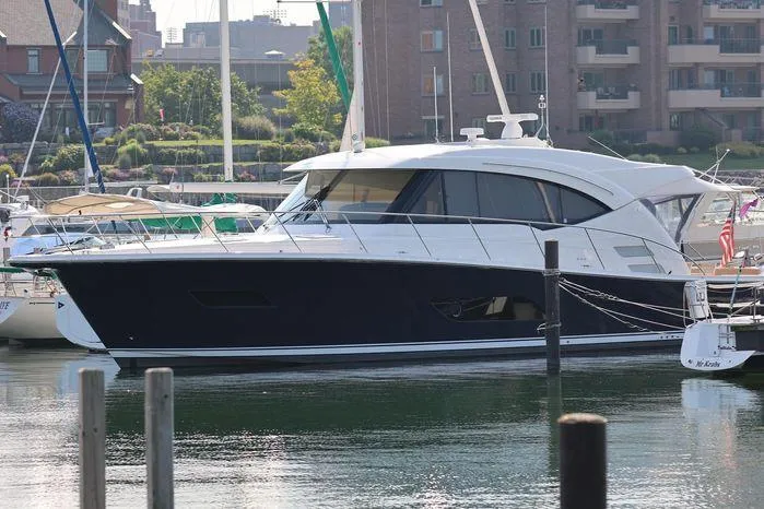 Eagle Yacht Photos Pics 2016 Riviera 525 SUV yacht docked in a marina, surrounded by other boats.