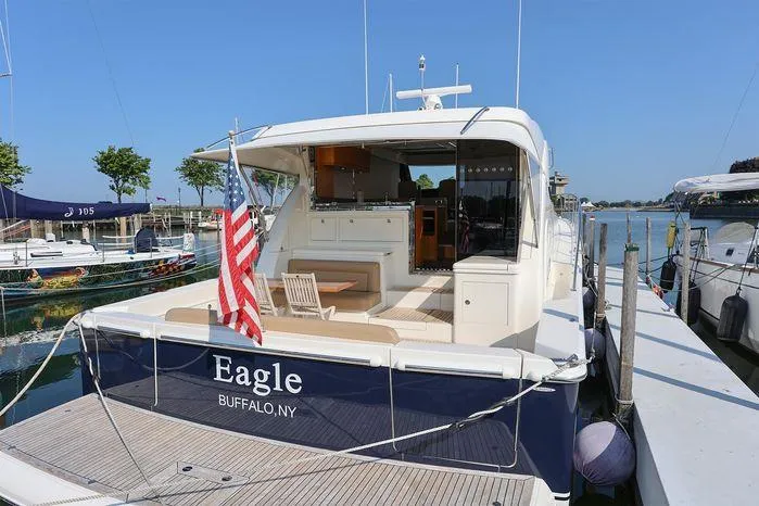 Eagle Yacht Photos Pics 2016 Riviera 525 SUV yacht docked, featuring spacious deck and American flag.