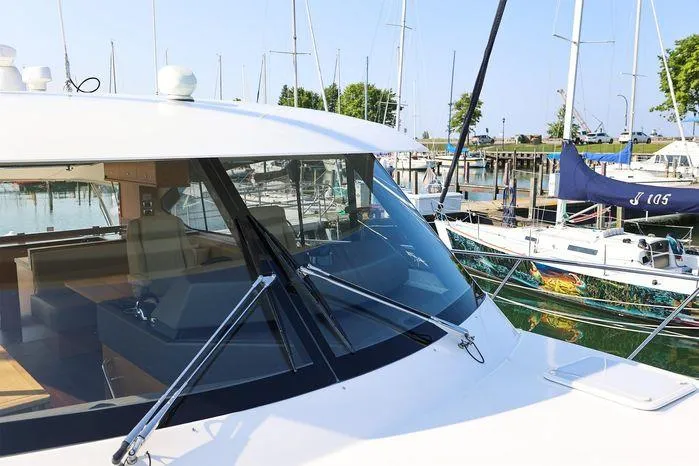 Eagle Yacht Photos Pics 2016 Riviera 525 SUV yacht docked at marina with sailboats in background.