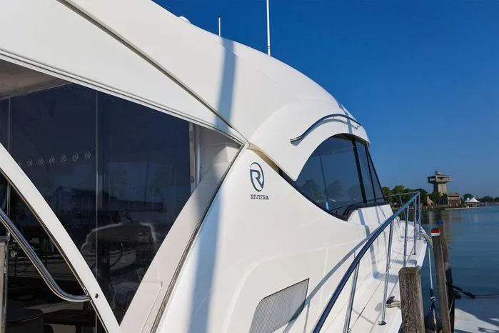 Eagle Yacht Photos Pics 2016 Riviera 525 SUV yacht docked by calm waters.