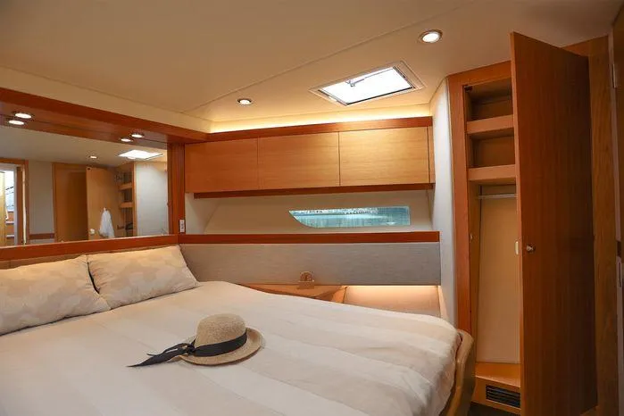 Eagle Yacht Photos Pics Luxurious bedroom interior of 2016 Riviera 525 SUV yacht with cozy bed and wooden cabinetry.