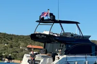 2023 Cranchi E52F yacht on water, featuring a British flag and scenic background.