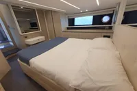 Luxurious bedroom interior of 2023 Cranchi E52F yacht with modern design and cozy bedding.