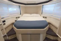 Luxurious 2023 Cranchi E52F yacht bedroom with modern design and cozy bedding.
