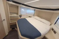 2023 Cranchi E52F yacht bedroom with modern design and cozy bedding.