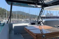 2023 Cranchi E52F yacht interior with sleek seating and polished table, docked in a scenic marina.