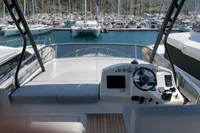 2023 Cranchi E52F yacht helm with marina view, featuring modern controls and seating.
