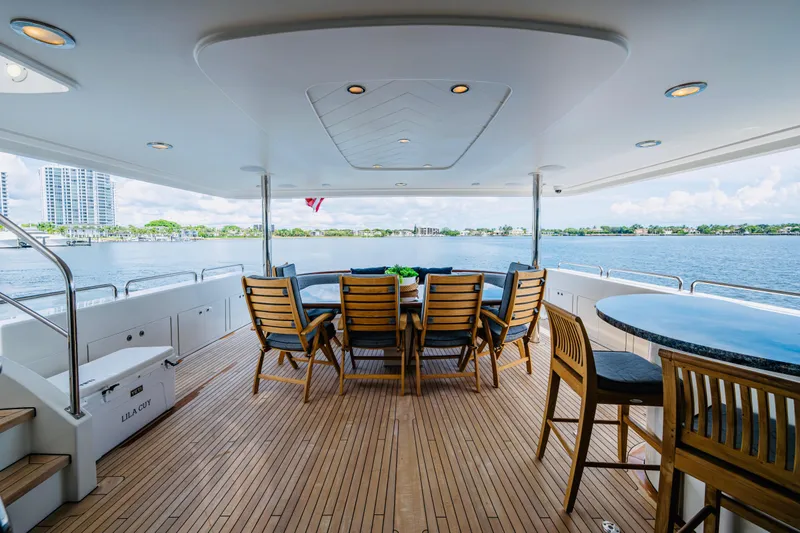 Lila Cuy Yacht Photos Pics Luxurious 2006 Westport w112 yacht deck with wooden furniture and scenic waterfront view.