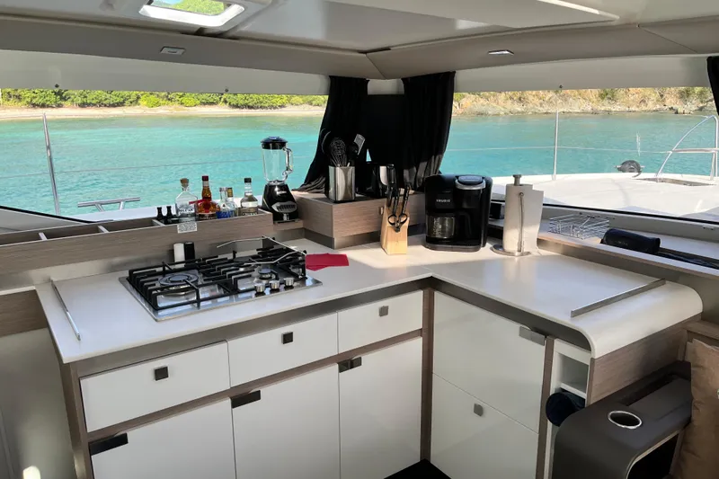 Family Therapy Yacht Photos Pics Modern kitchen interior of 2023 Fountaine Pajot Elba 45 Catamaran with ocean view.