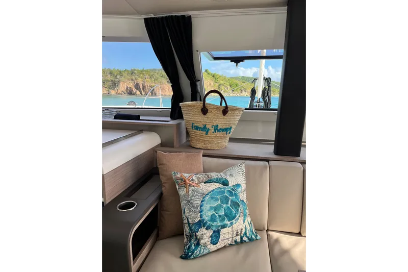 Family Therapy Yacht Photos Pics 2023 Fountaine Pajot Elba 45 Catamaran interior with ocean view, decorative pillow, and beach bag.