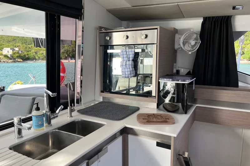 Family Therapy Yacht Photos Pics Modern kitchen interior of 2023 Fountaine Pajot Elba 45 Catamaran with ocean view.
