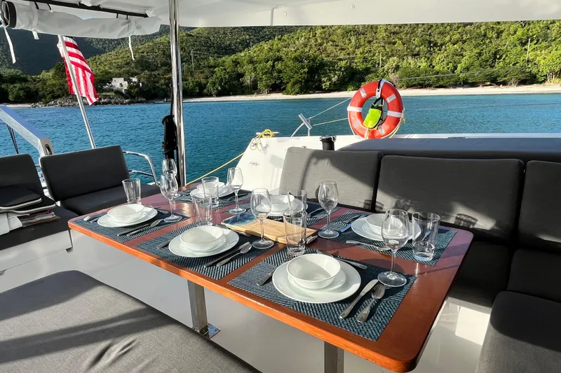 Family Therapy Yacht Photos Pics Elegant dining setup on 2023 Fountaine Pajot Elba 45 Catamaran, overlooking serene coastal waters.