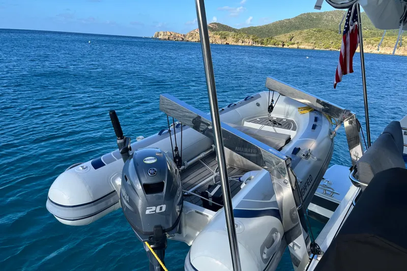 Family Therapy Yacht Photos Pics 2023 Fountaine Pajot Elba 45 Catamaran with dinghy on blue ocean waters.