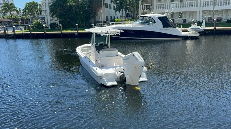  Yacht Photos Pics 2024 Everglades 253 Center Console boat on calm water near a dock.