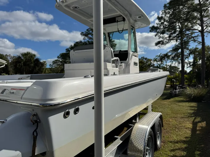  Yacht Photos Pics 2024 Everglades 253 Center Console boat on trailer, parked outdoors under blue sky.
