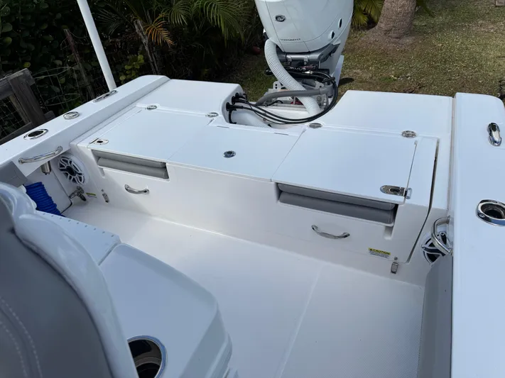  Yacht Photos Pics 2024 Everglades 253 Center Console boat deck with storage compartments and motor.