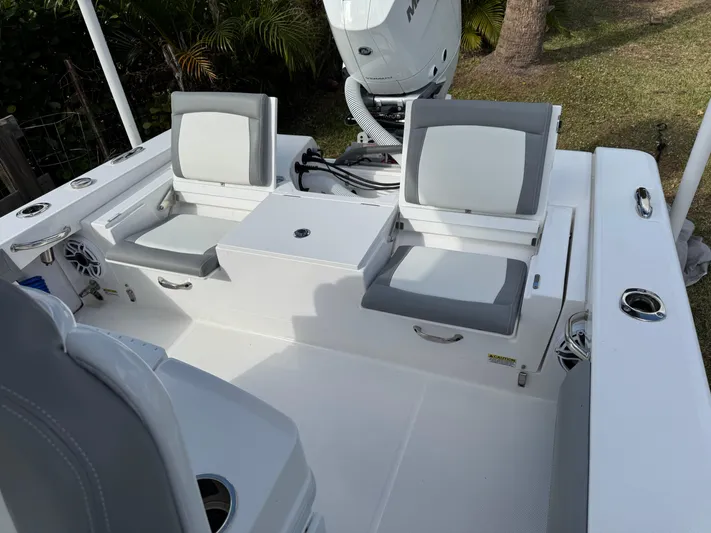  Yacht Photos Pics 2024 Everglades 253 Center Console boat interior with cushioned seating and motor.