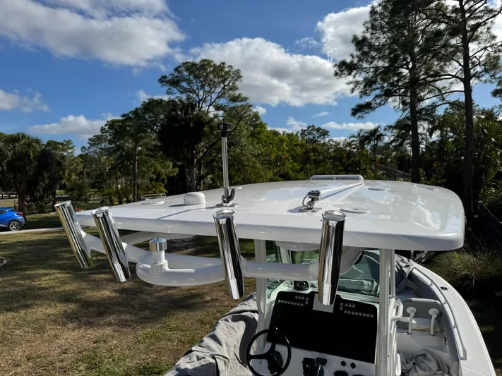  Yacht Photos Pics 2024 Everglades 253 Center Console boat with rod holders, set against a scenic outdoor backdrop.
