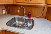 Kitchen sink area in 2005 Vripack Spiegelkotter 14.50 yacht with wooden cabinetry.