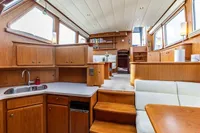 Luxurious 2005 Vripack Spiegelkotter 14.50 yacht interior with wood cabinetry and cozy seating.