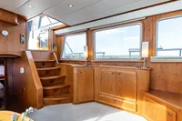Elegant interior of 2005 Vripack Spiegelkotter 14.50 yacht with wooden cabinetry and large windows.