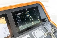 ```json
"Boat navigation system on Vripack Spiegelkotter 14.50, 2005 model, featuring radar and GPS displays."
```