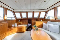 Luxurious interior of 2005 Vripack Spiegelkotter 14.50 yacht with elegant wood finish and cozy seating.