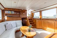 Luxurious interior of 2005 Vripack Spiegelkotter 14.50 yacht with wooden furnishings and cozy seating.