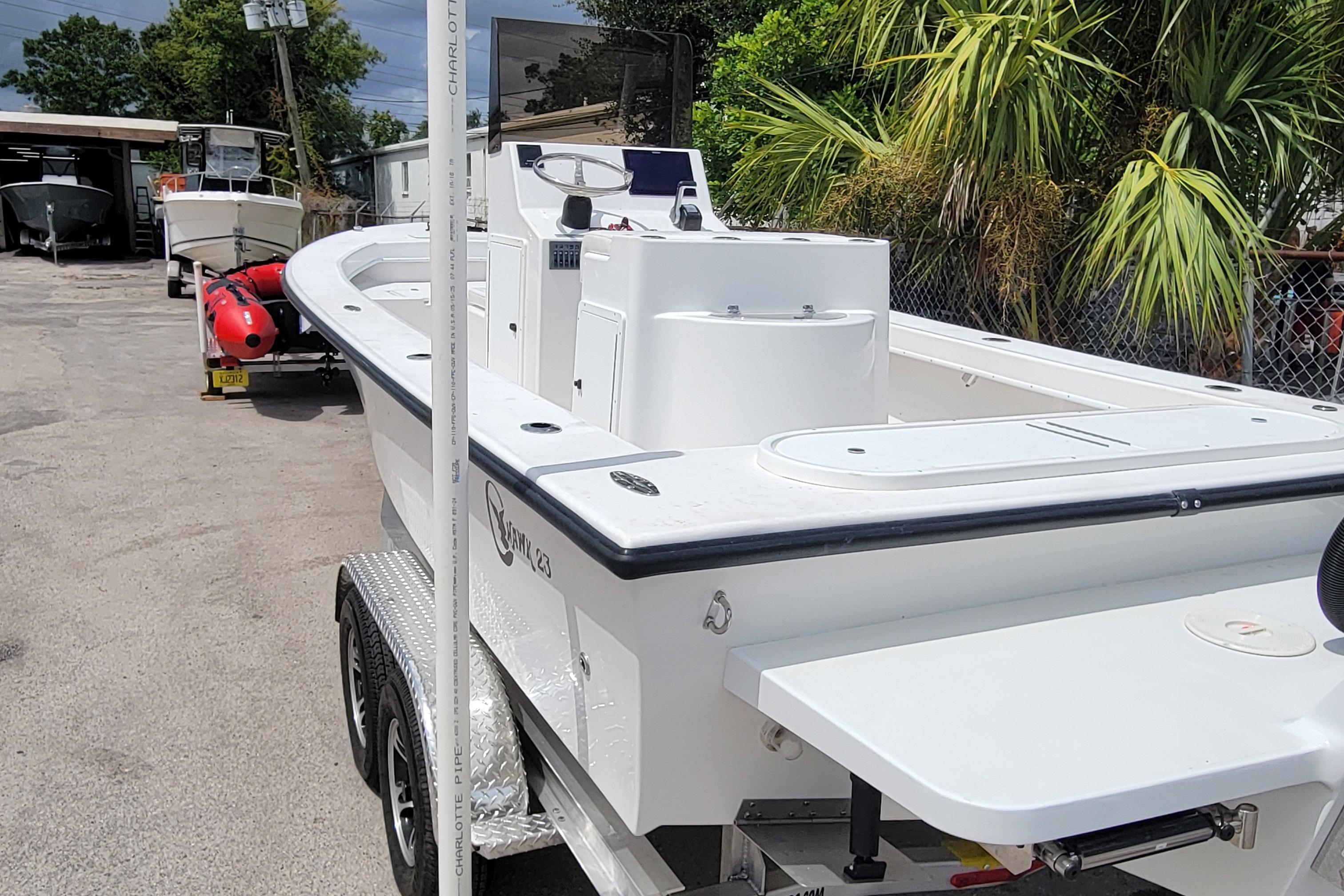 2025 C-Hawk 23CC boat on trailer, parked outdoors near palm trees.