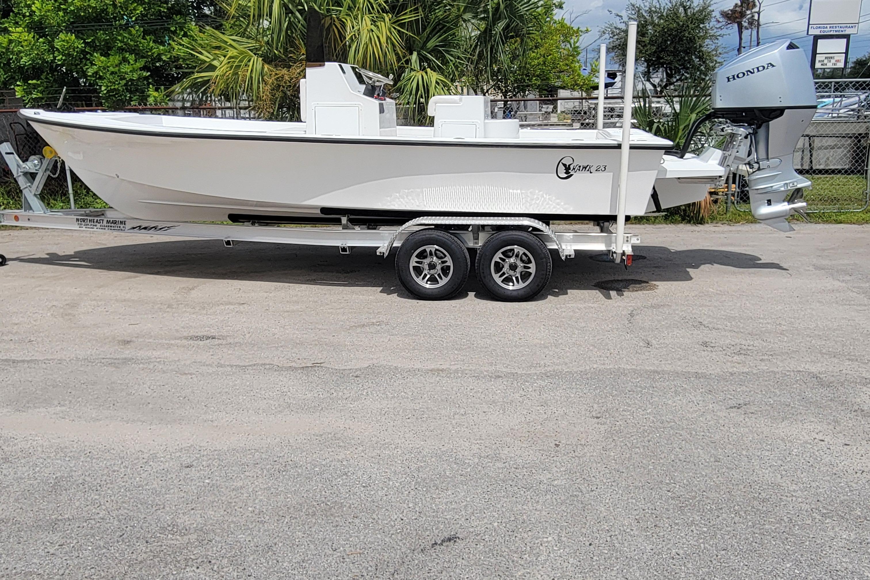 2025 C-Hawk 23CC boat on trailer with Honda outboard motor, parked outdoors.