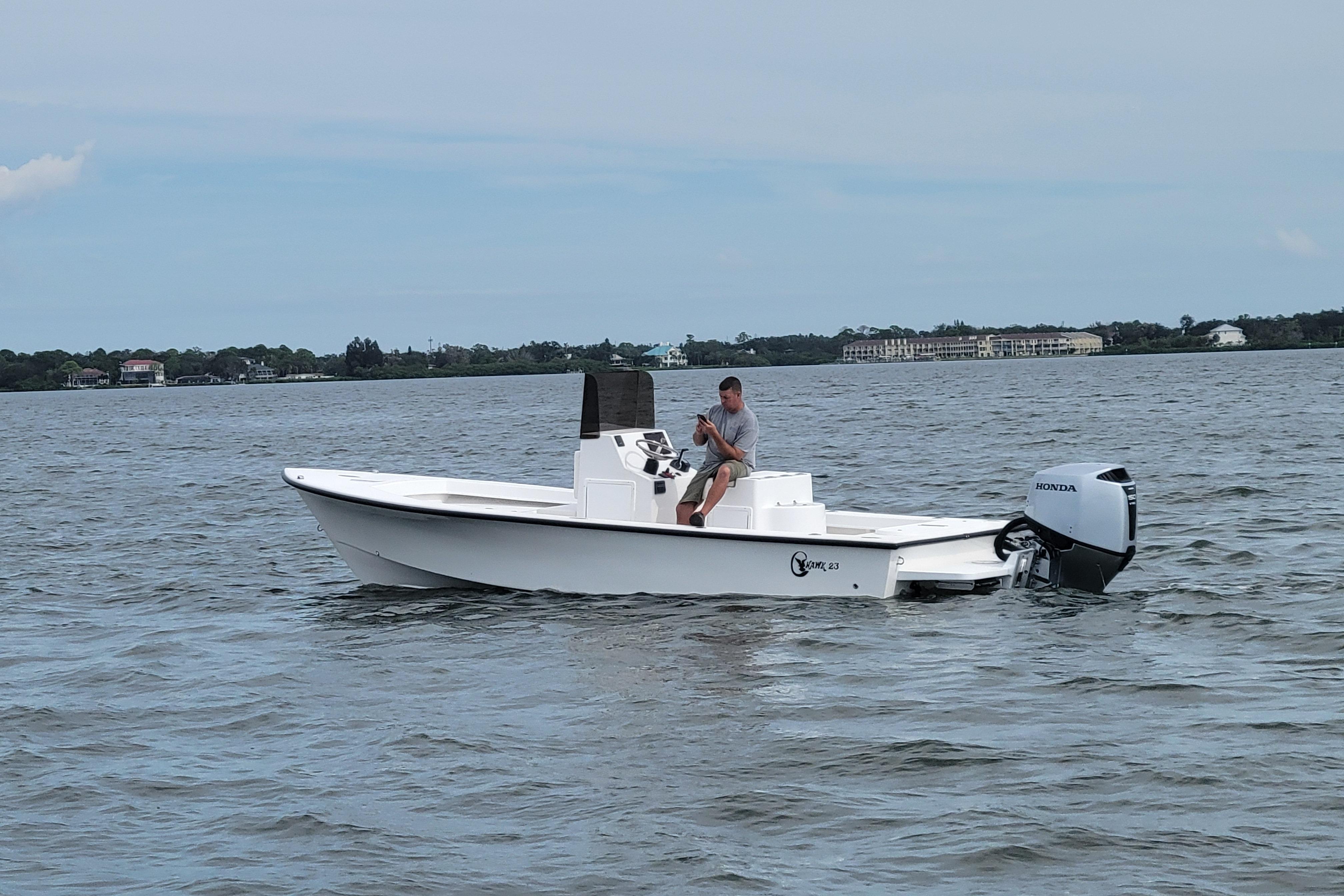 2025 C-Hawk 23CC boat with Honda outboard motor on calm water.