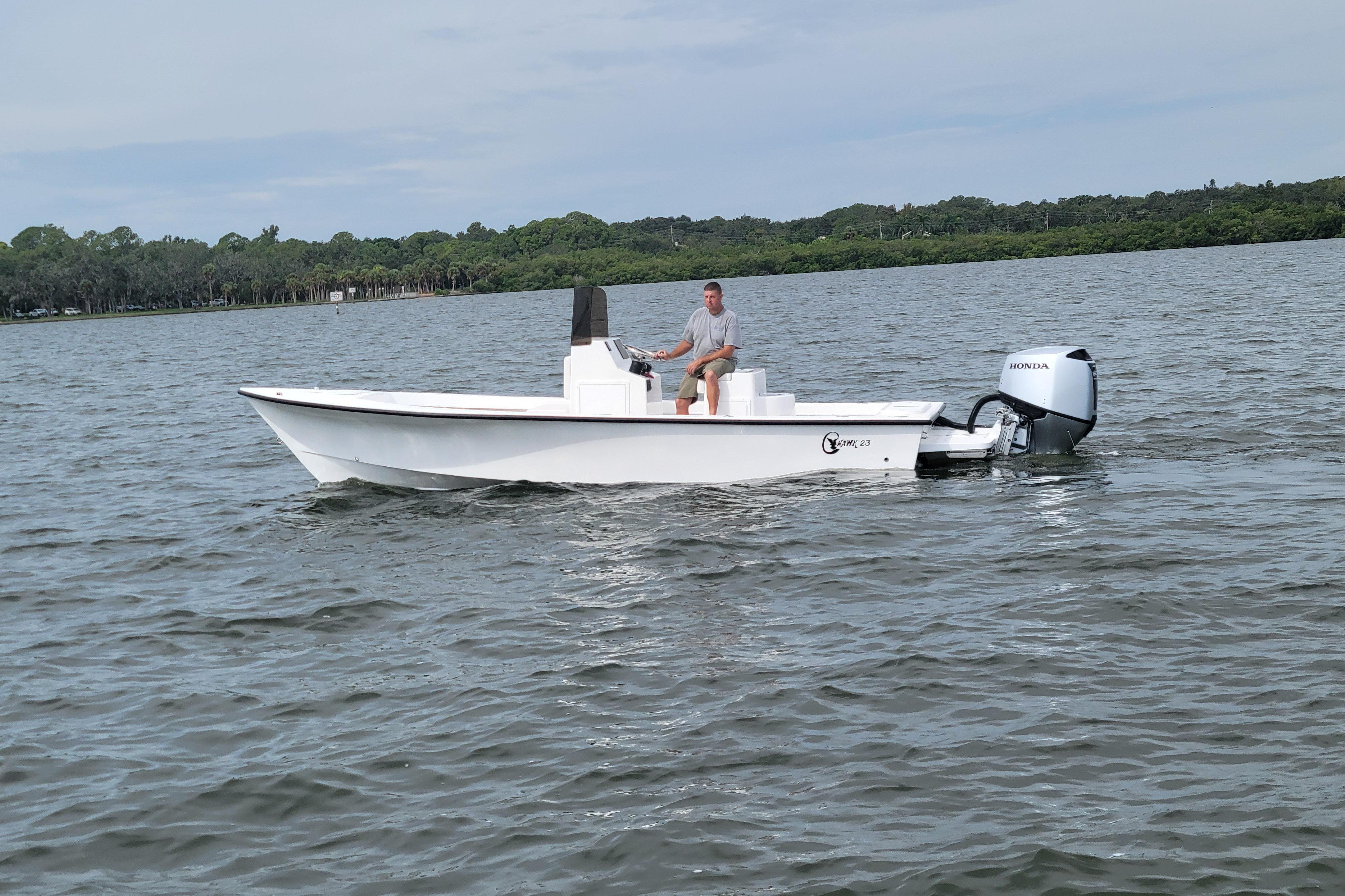 2025 C-Hawk 23CC boat on calm water with Honda outboard motor.