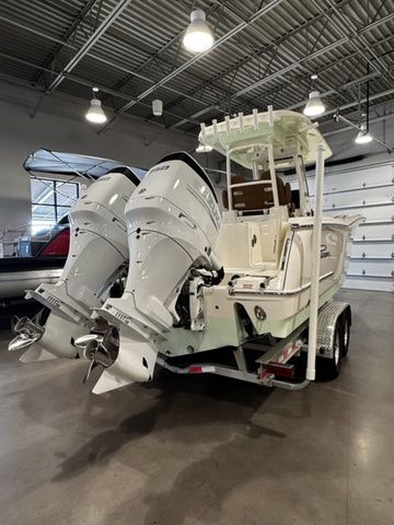 2025 Pioneer Pelagic 270 boat with dual outboard engines in a spacious indoor showroom.