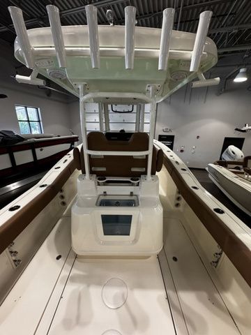 2025 Pioneer Pelagic 270 boat interior with rod holders and seating in a showroom.