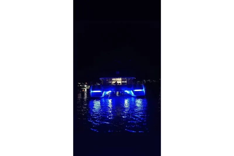  Yacht Photos Pics Lagoon 560 S2 yacht with blue lights reflecting on water at night, 2014 model.